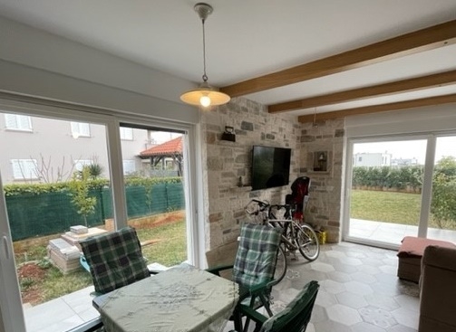 Pièce lumineuse avec poutres en bois et deux portes de terrasse