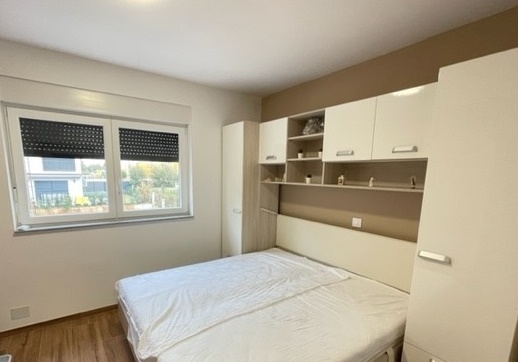 Chambre avec placard en surplomb et fenêtre avec store