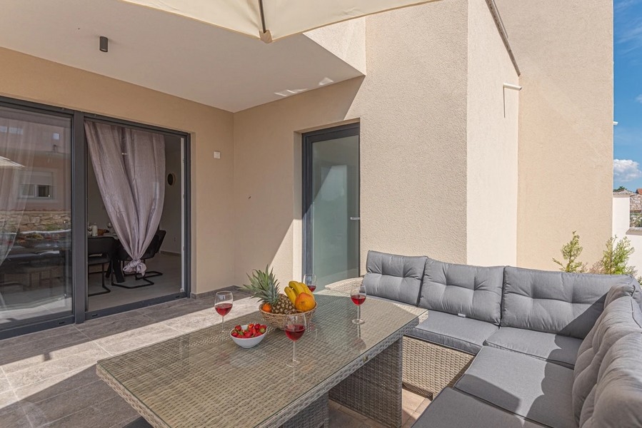 Terrasse avec salon en rotin et table dressée