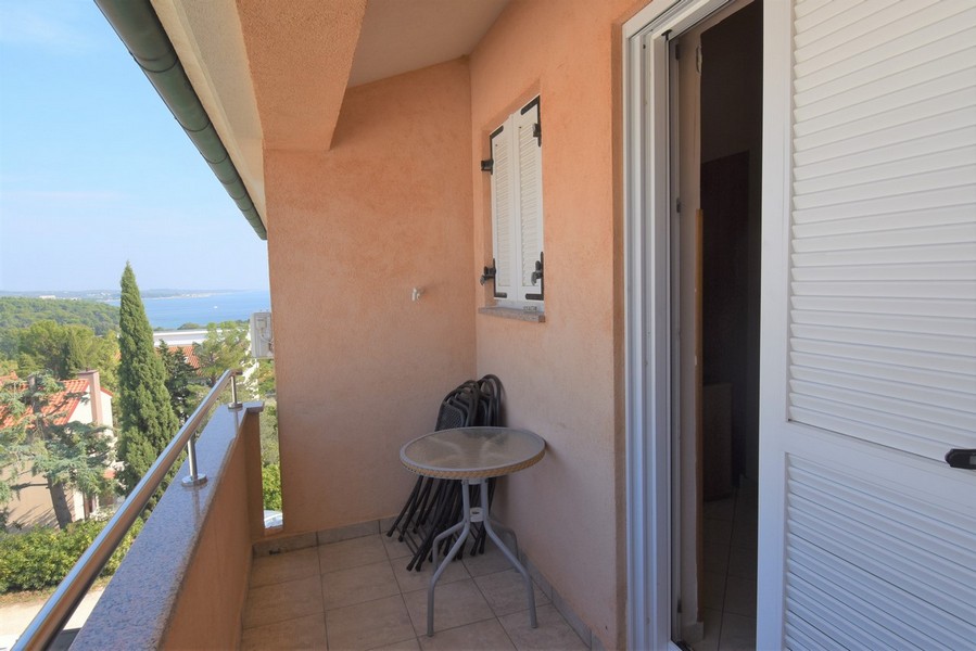 Balcon étroit avec table pliante et vue sur la baie