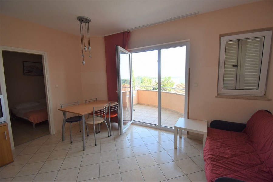 Séjour avec table à manger et porte ouverte sur le balcon