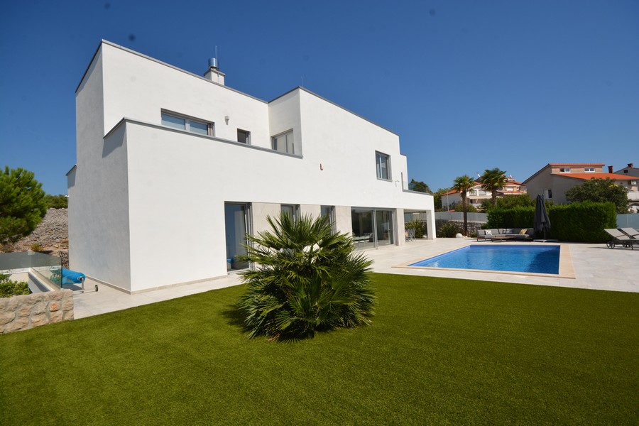 Villa blanche avec palmier dans le gazon synthétique et piscine à côté