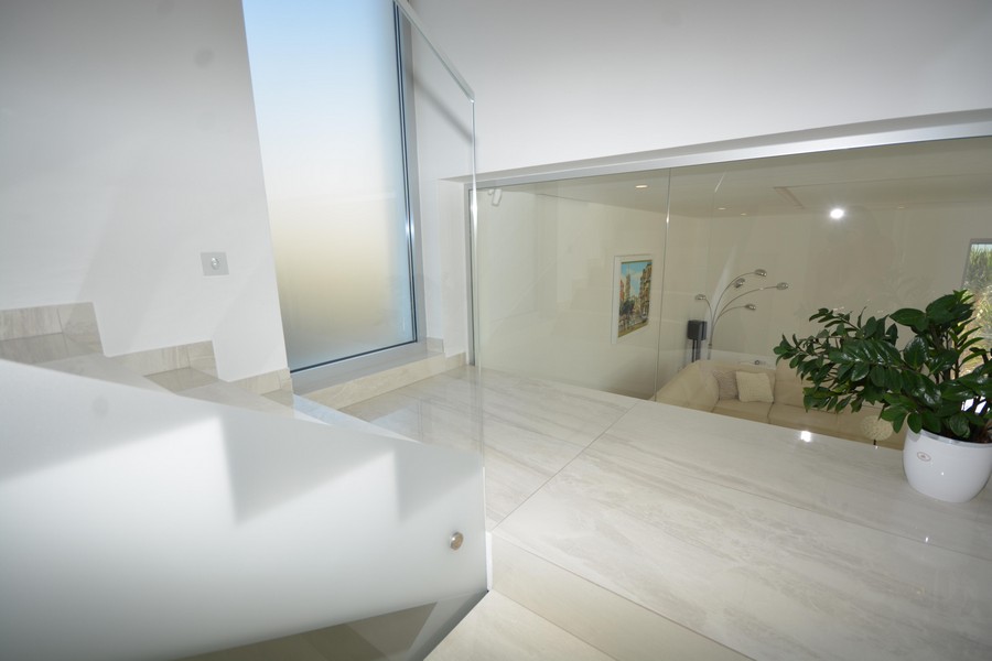 Espace escalier avec paroi en verre et vue sur la pièce