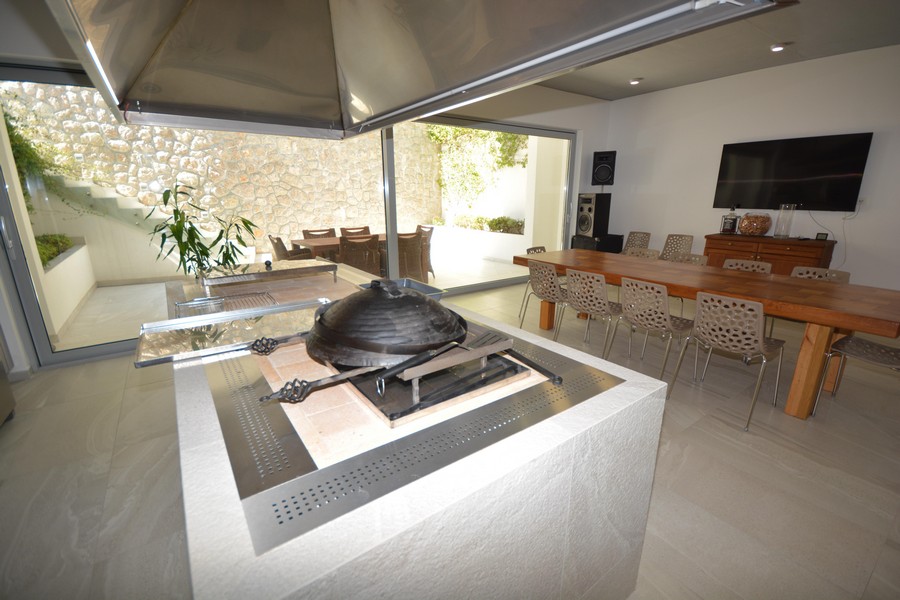 Cuisine d'été avec barbecue et longue table en bois