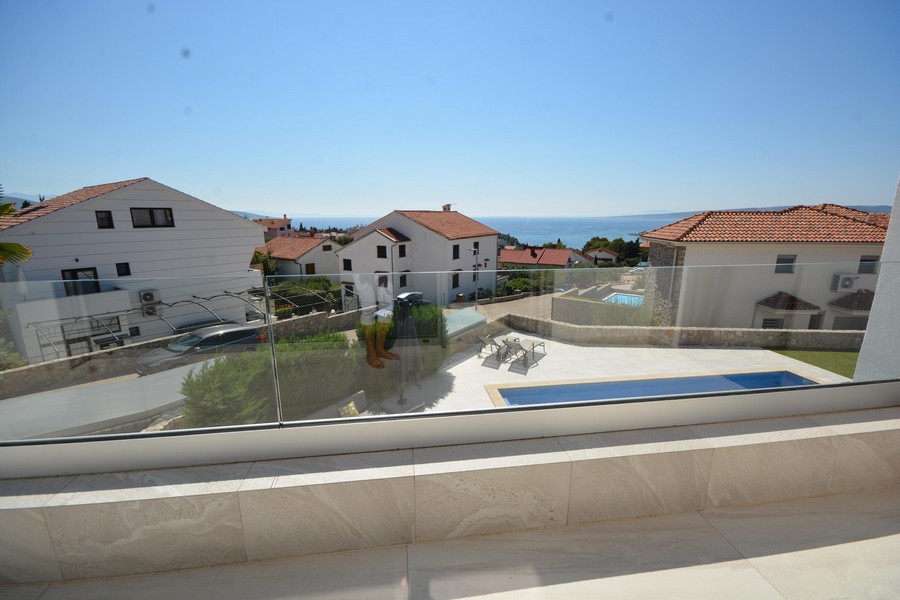 Vue depuis le balcon sur la piscine et les maisons voisines