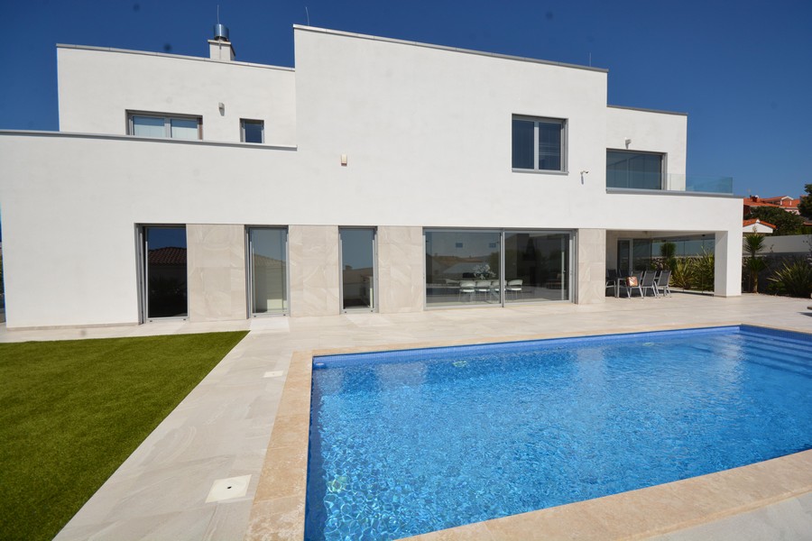 Villa blanche avec piscine et pelouse au soleil
