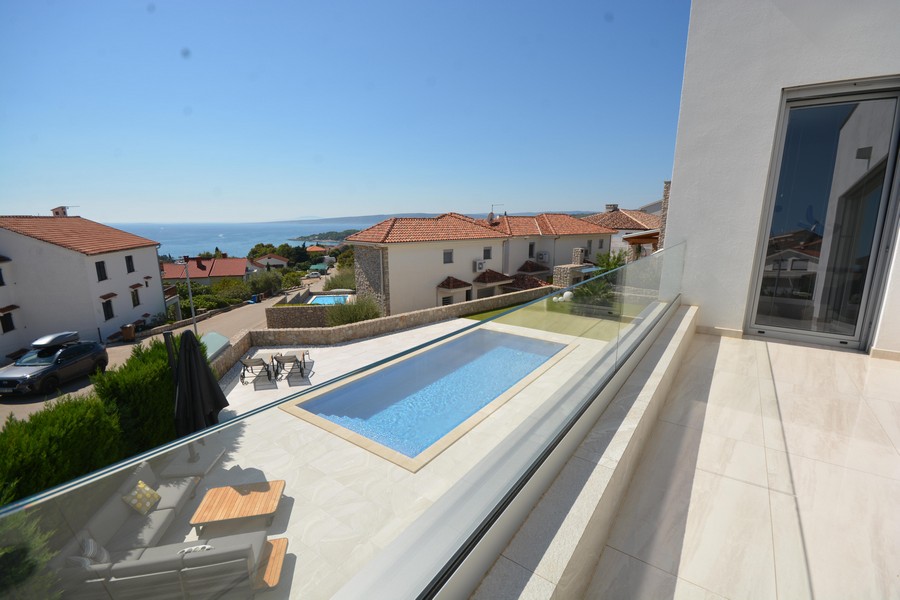 Vue depuis le balcon sur la piscine, les toits et la mer