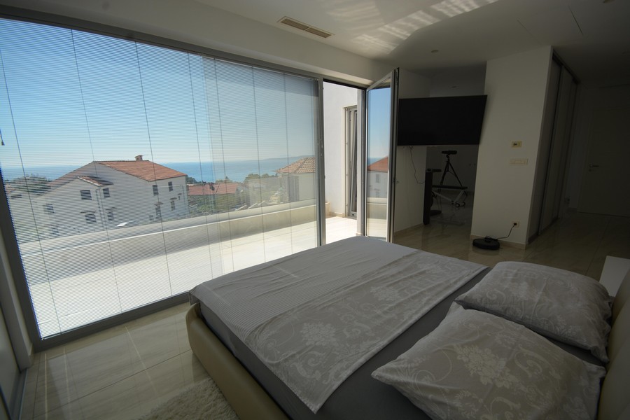 Chambre avec fenêtre panoramique et persiennes donnant sur la mer