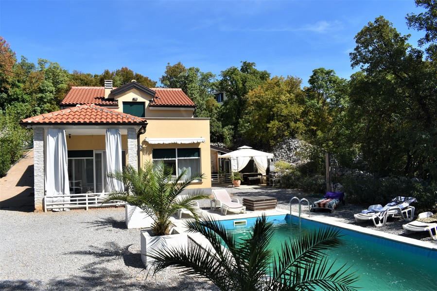 Maison à Kostrena avec piscine et palmier dans un jardin de gravier