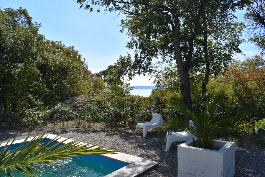 Bord de piscine avec chaises longues et échappée sur la mer