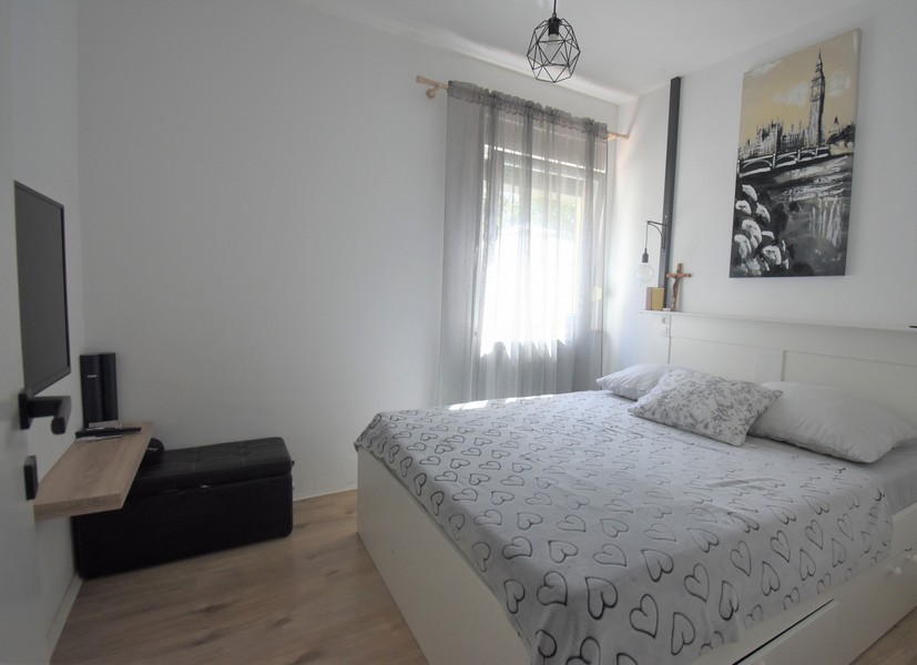 Chambre avec télévision et tableau au-dessus du lit