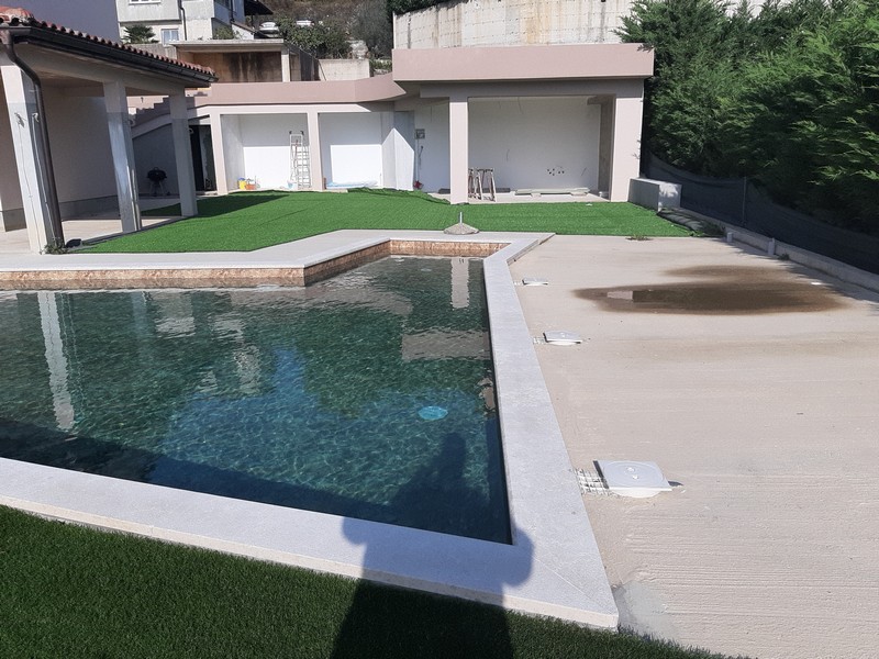 Piscine à revêtement foncé devant les garages