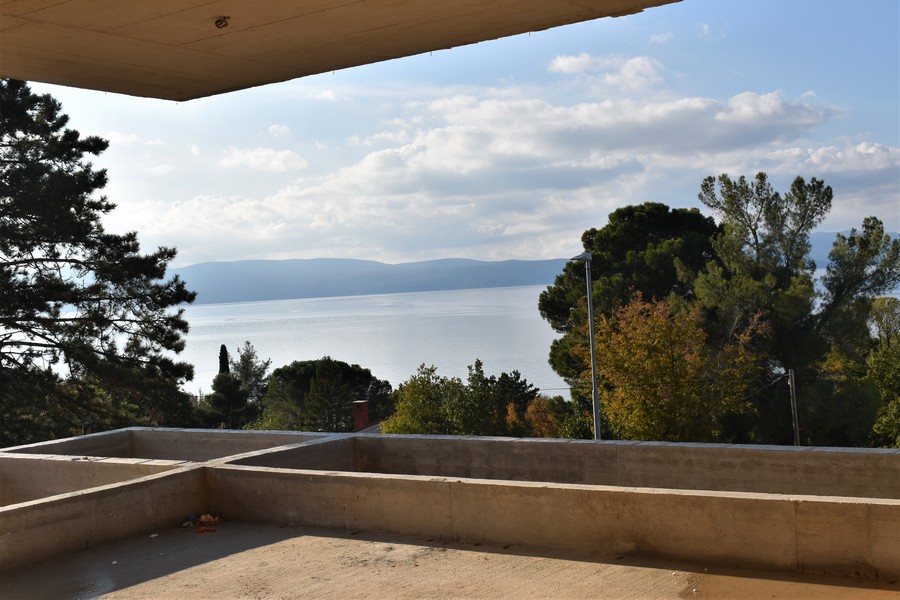 Vue depuis la terrasse en gros œuvre à travers les arbres sur la baie
