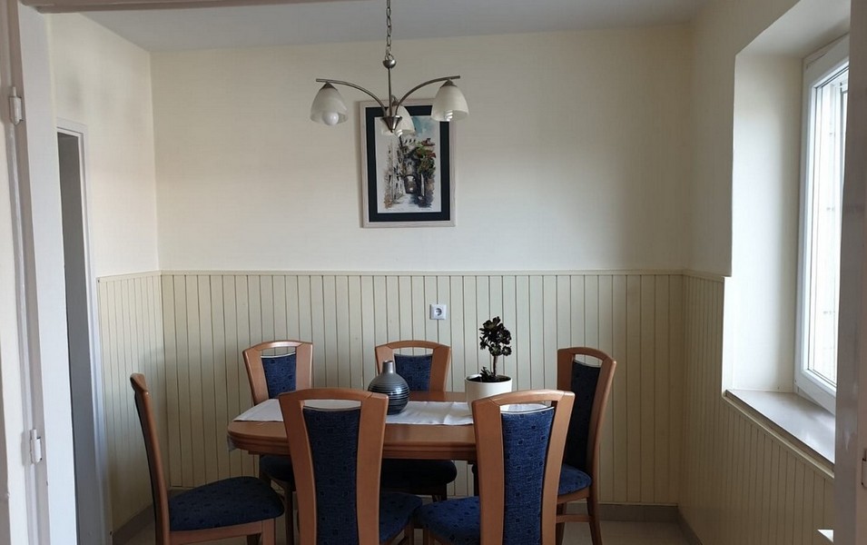 Salle à manger avec table en bois et chaises rembourrées bleues