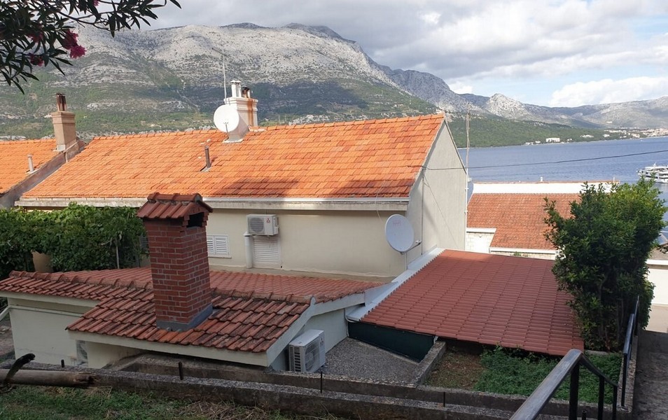 Vue sur les toits de tuiles, le détroit et les montagnes