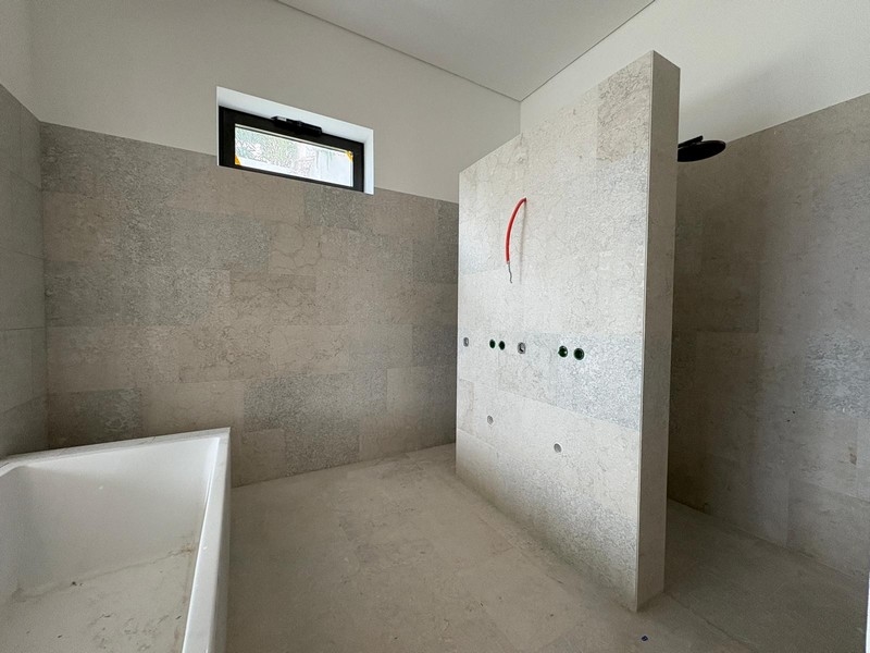 Salle de bains inachevée avec carrelage en pierre et espace douche