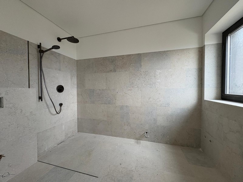 Douche à l'italienne avec pomme de douche pluie et carrelage en pierre