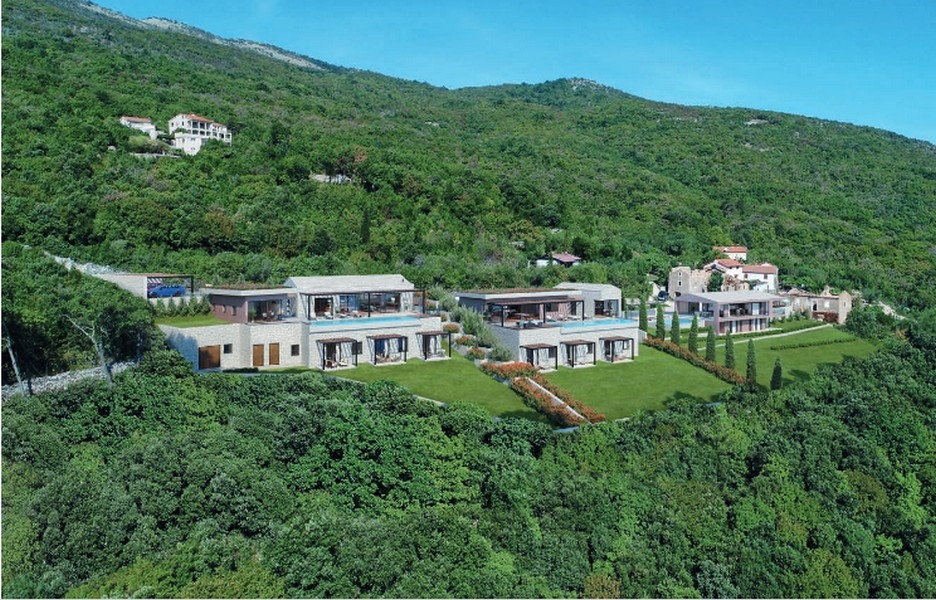 Vue aérienne de plusieurs villas avec piscines sur la pente boisée