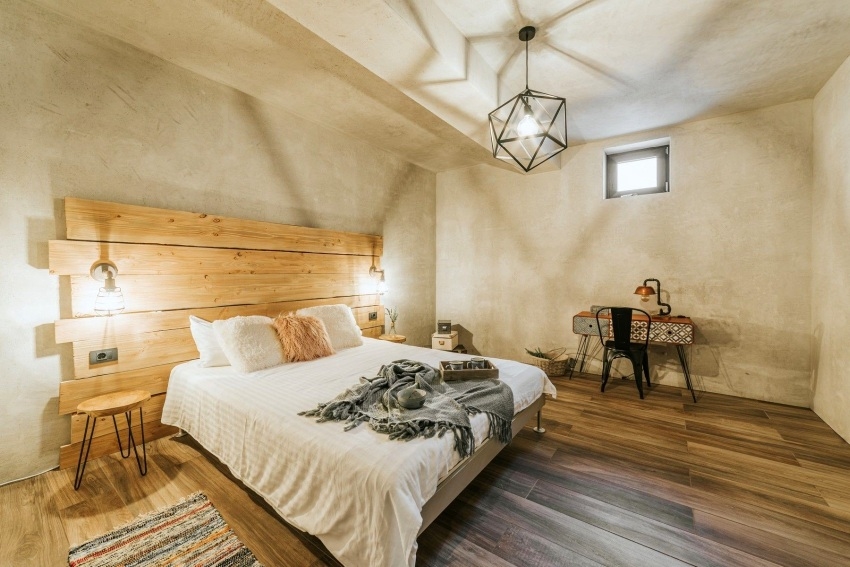 Chambre avec lit double et tête de lit en bois