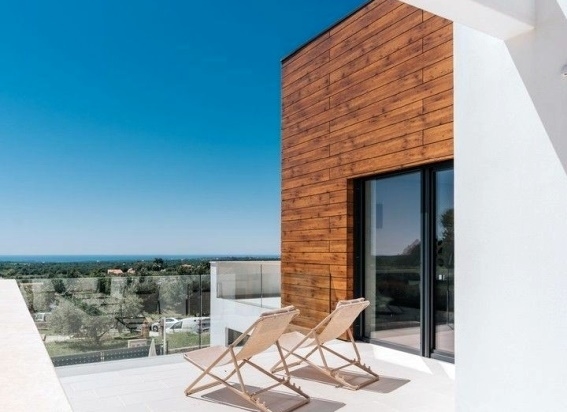 Chaises longues sur la terrasse devant la façade en bois