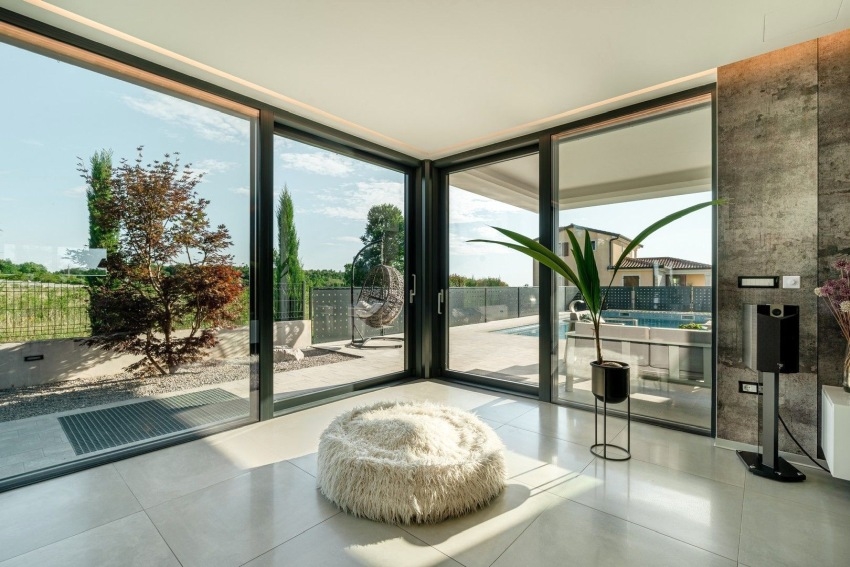 Pièce à vitrage d'angle et pouf avec vue sur la piscine