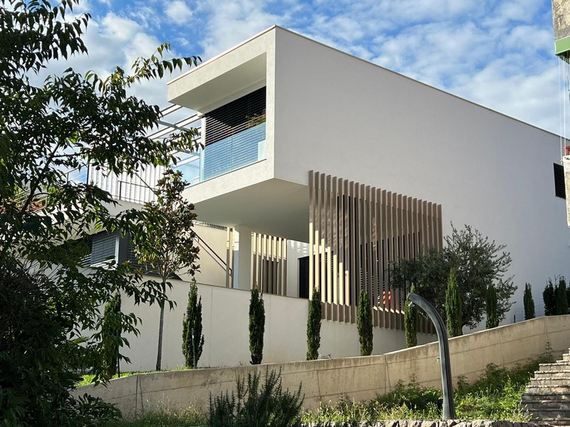 Villa moderne avec lames de bois et cyprès au bord de la route