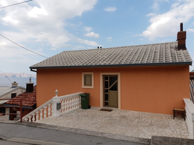 Maison orange avec terrasse en pierre et balustrade