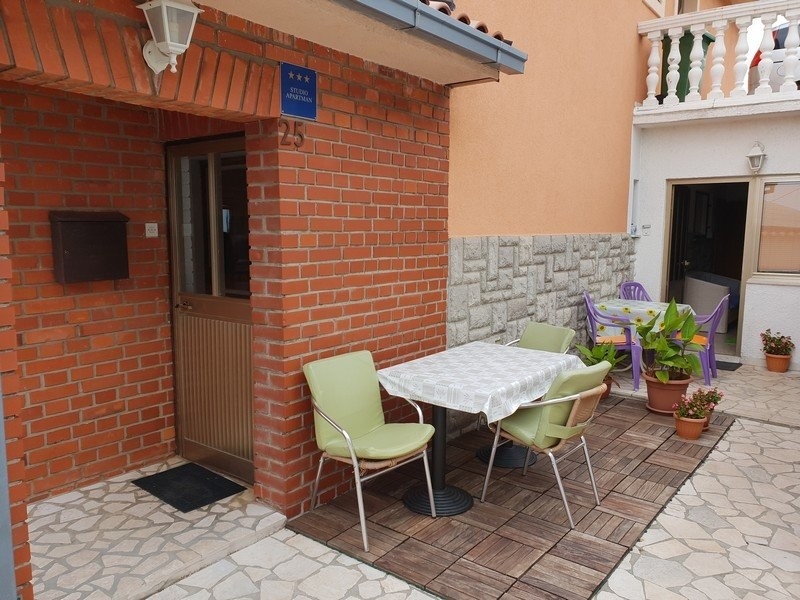 Coin salon avec table et chaises devant l'entrée en briques