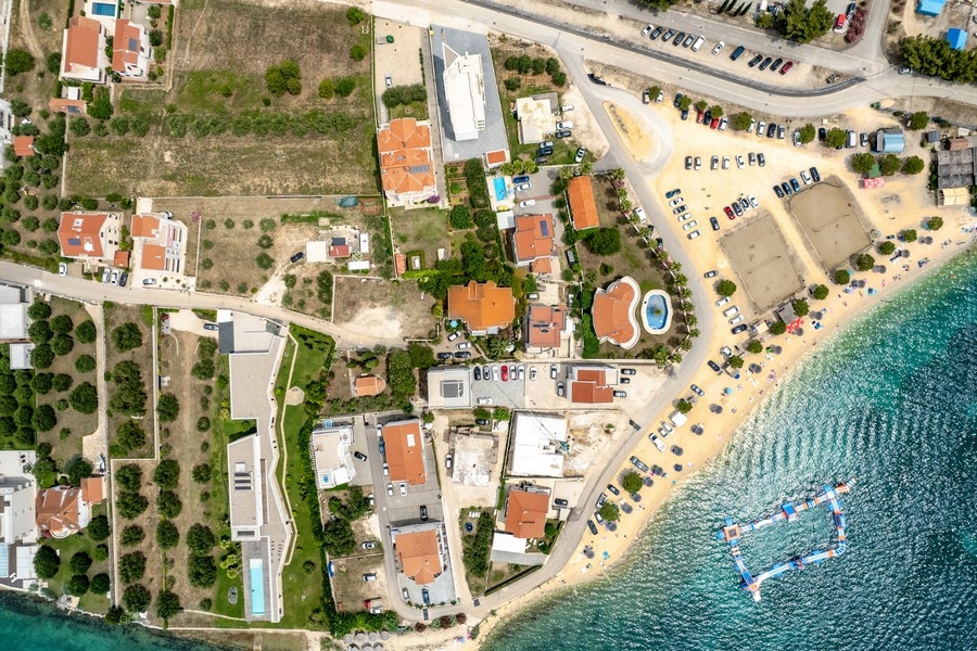 Vue aérienne du quartier résidentiel avec plage de sable et plateforme de baignade