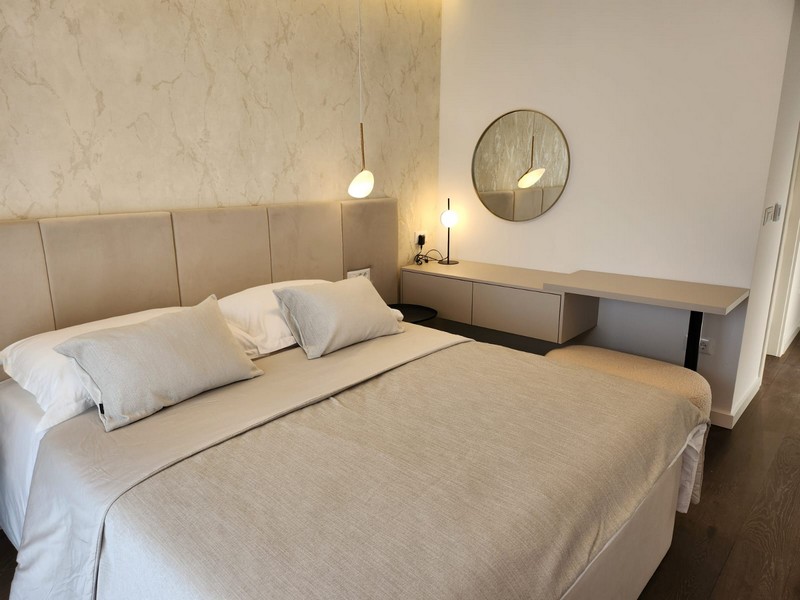 Chambre avec lit double et miroir rond au-dessus de la console