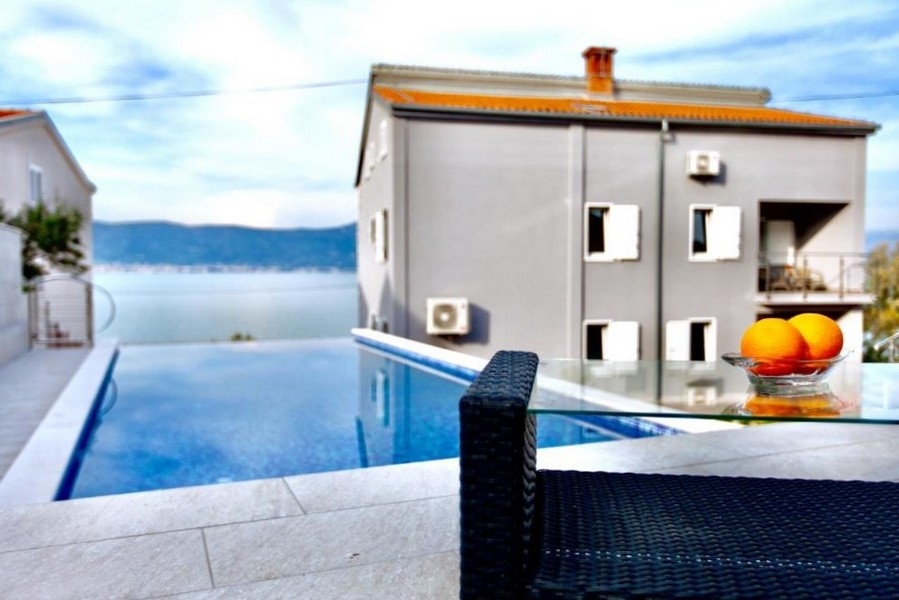 Piscine devant la maison avec corbeille de fruits sur la table