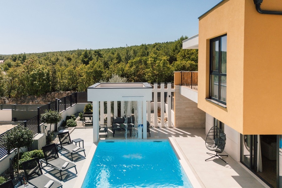 Piscine avec coin salon couvert et vue sur la verdure