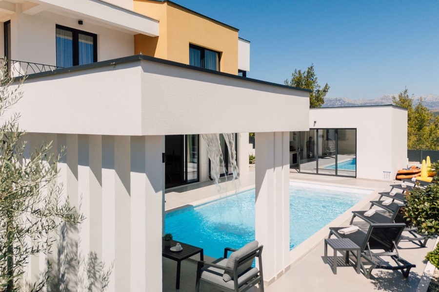 Terrasse de la piscine avec bains de soleil et coin salon couvert