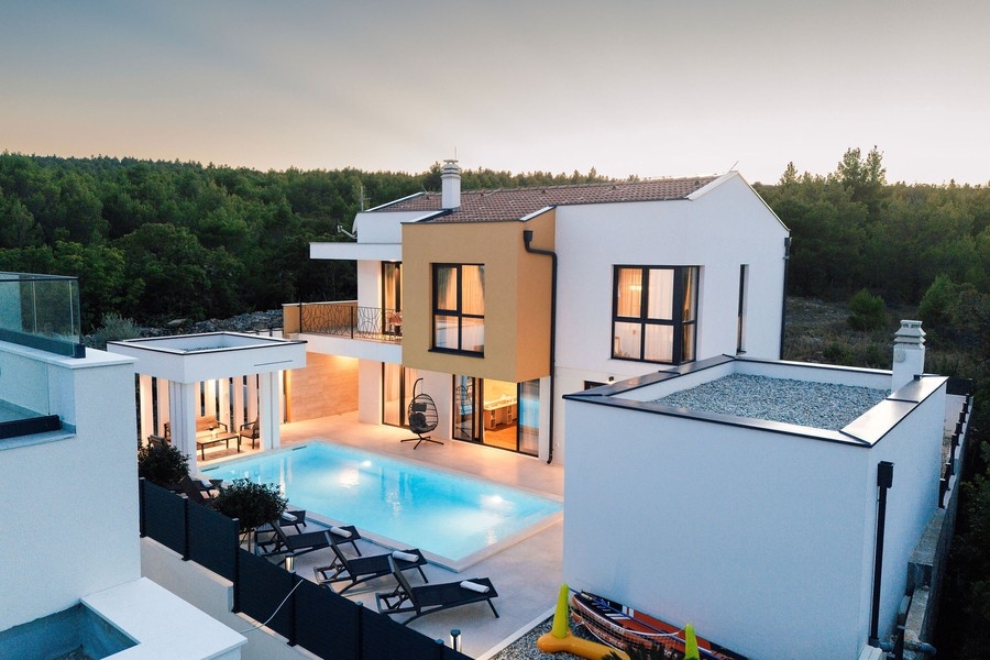 Villa avec piscine éclairée au crépuscule