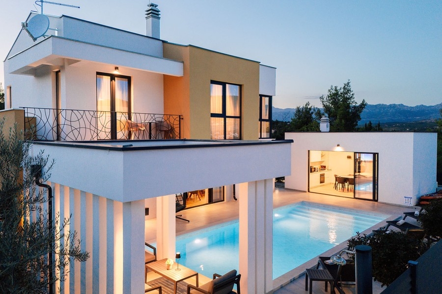 Balcon et terrasse couverte au bord de la piscine à la lumière du soir