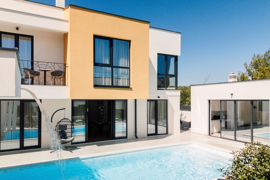 Espace piscine avec cascade devant la façade de la maison