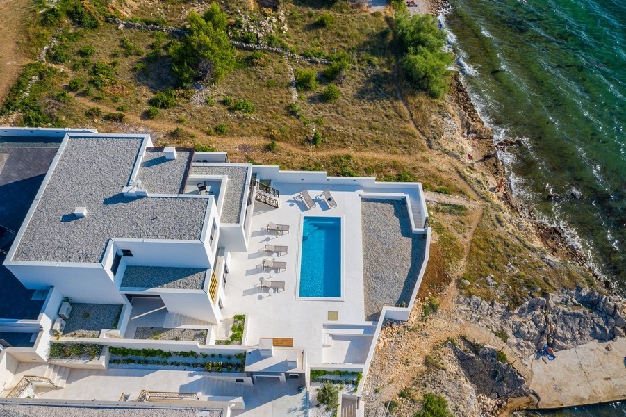 Vue aérienne de la villa avec piscine directement au-dessus de la côte rocheuse