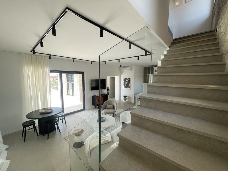 Escalier ouvert avec garde-corps en verre à côté du coin repas