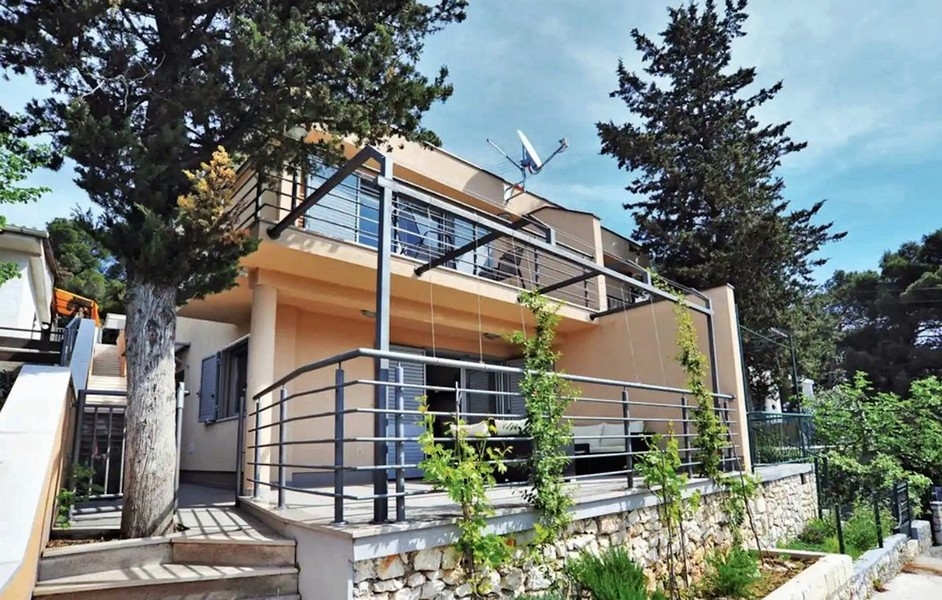 Maison avec garde-corps en acier et pin devant la terrasse