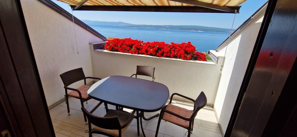 Terrasse avec table à manger et vue sur la mer