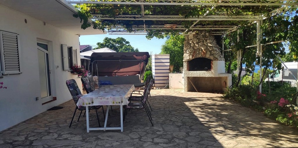 Terrasse avec coin repas couvert et barbecue.