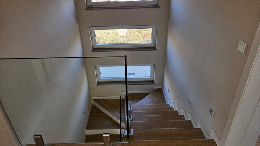 Vue de dessus de l'escalier en bois avec garde-corps en verre