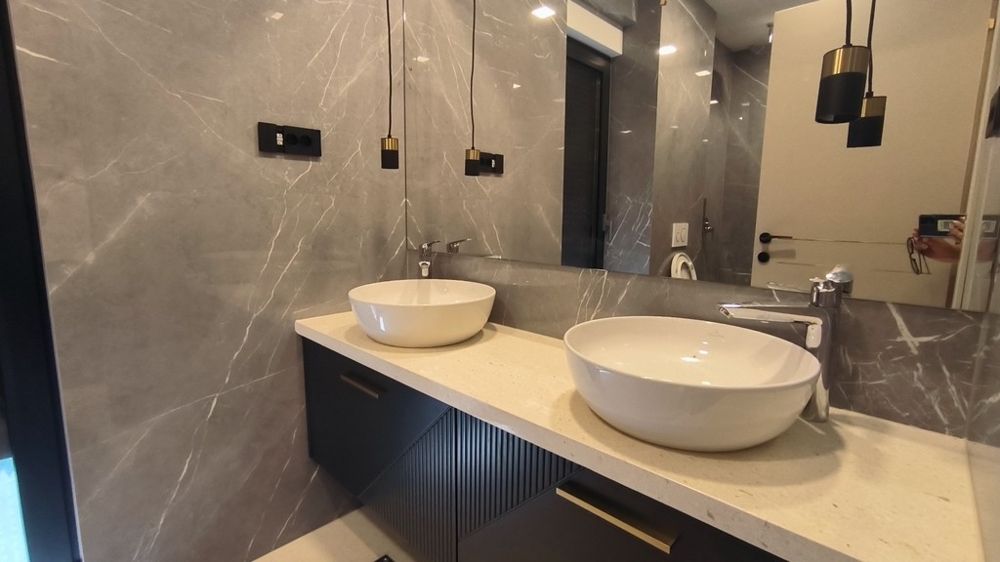 Salle de bains luxueuse avec deux lavabos et carrelage en marbre