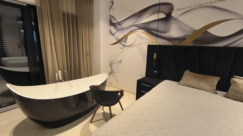 Chambre avec baignoire îlot et décoration murale élégante