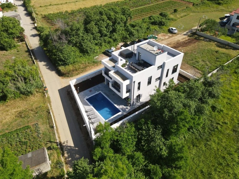 Vue aérienne d'une villa luxueuse avec piscine dans un cadre verdoyant