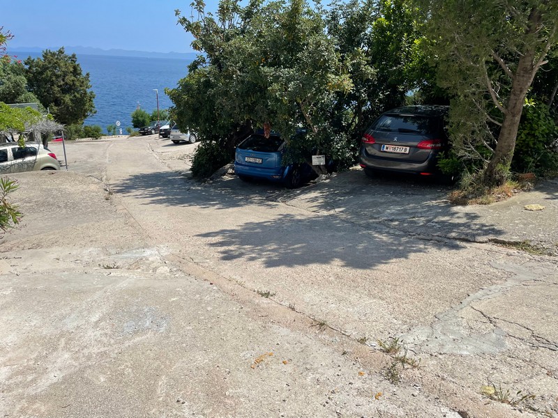 Place de parking à l'entrée du village. Bien H2653 en Croatie.