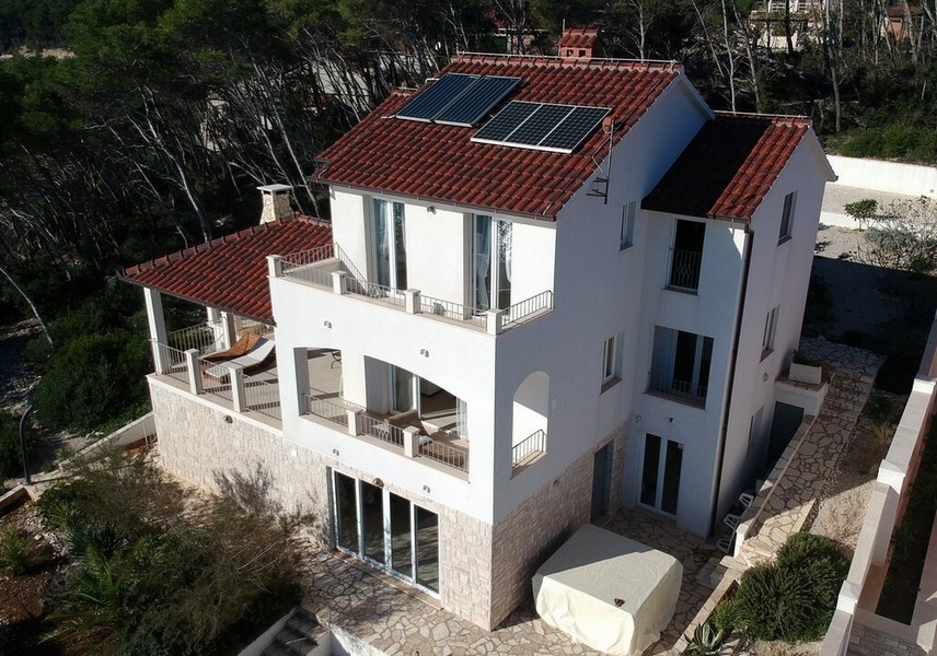 Maison blanche avec panneaux solaires et loggias vue du ciel