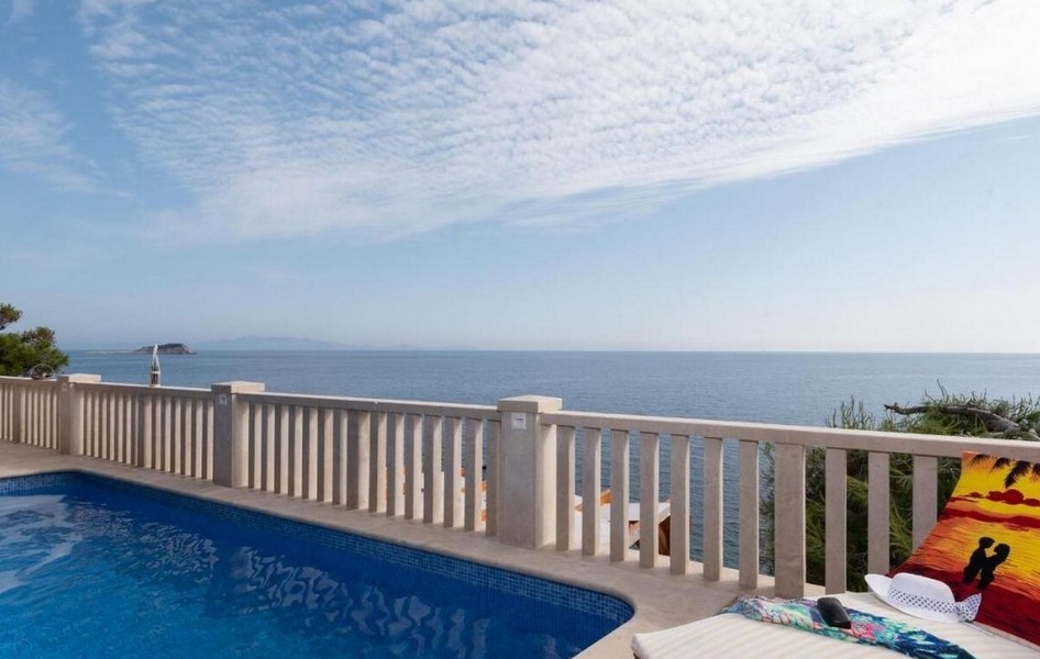 Piscine et terrasse directement au bord de la mer.