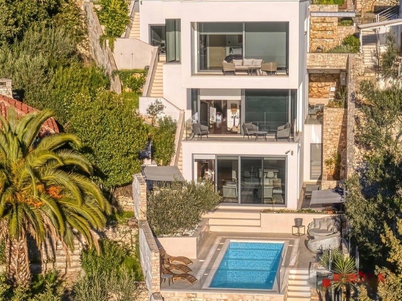 Villa blanche avec piscine et palmier vue du ciel