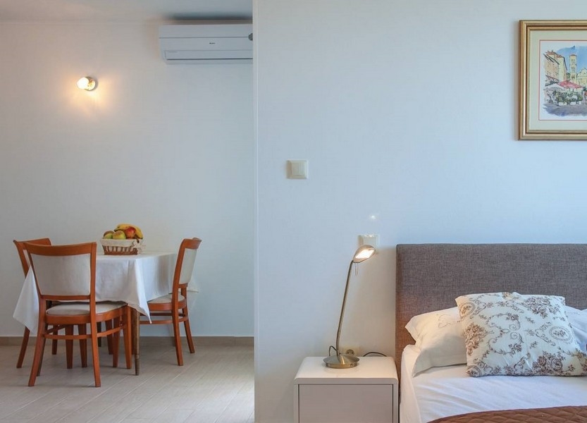 Coin repas climatisé et vue sur le lit.